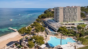Un hotel con piscina, playa y vista al océano.