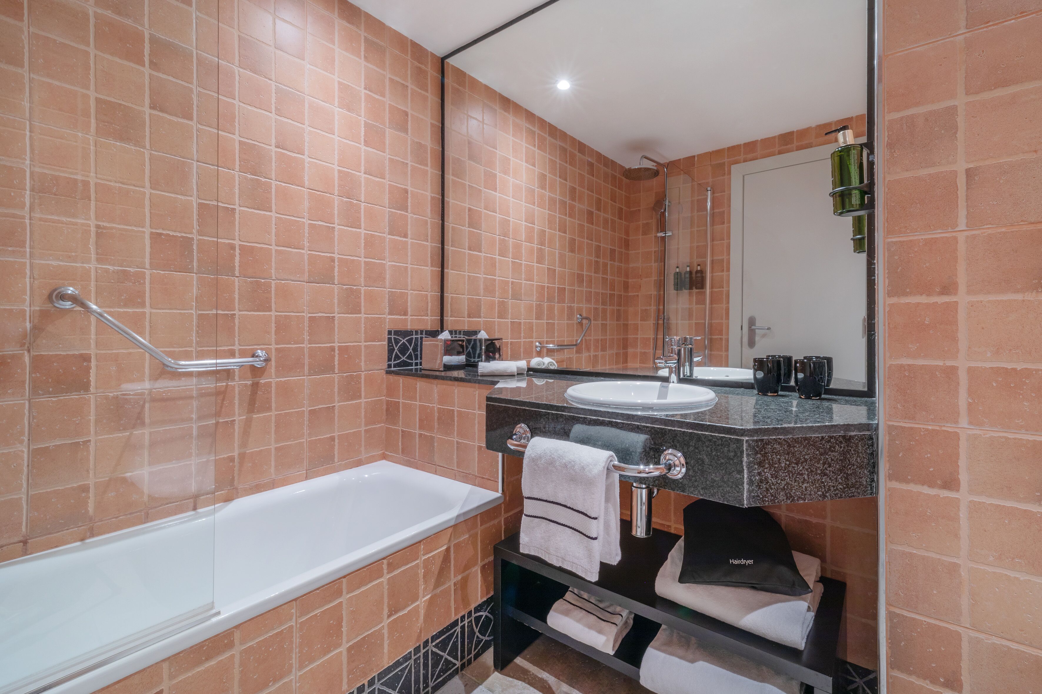 Un baño moderno con bañera, lavabo y tocador con espejo.