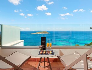 A balcony with a table set with macarons and two drinks, overlooking a turquoise sea and a small island. - Melia Calviá Beach (Calvia)