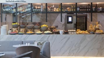 Un restaurant moderne doté d’un comptoir en marbre où sont présentés divers fruits et plats.