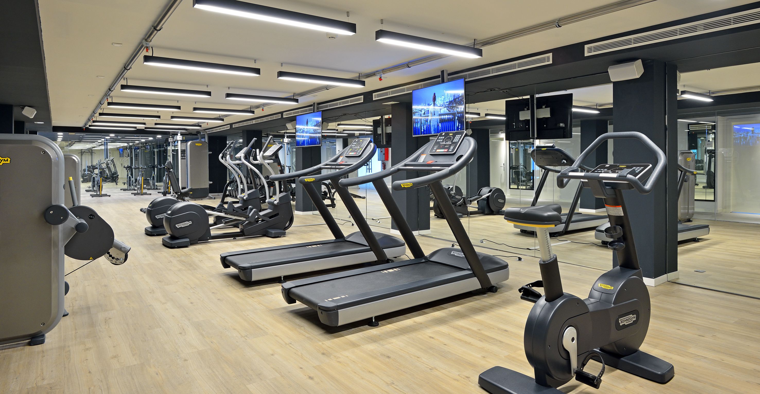 A gym with multiple treadmills, exercise bikes, and weight machines.