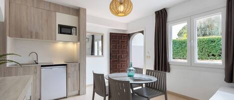 A modern kitchen with a dining area, a built-in microwave, and a sink.