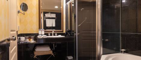 Un baño moderno con ducha de vidrio, una bañera grande y un tocador con espejo.