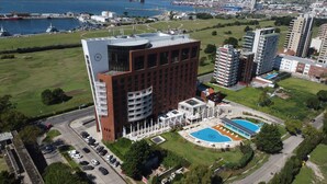 Ein Hochhaus mit Schwimmbad und Parkplatz.