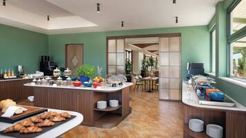 Una cocina moderna con barra desayunadora, zona de comedor y vistas al exterior.