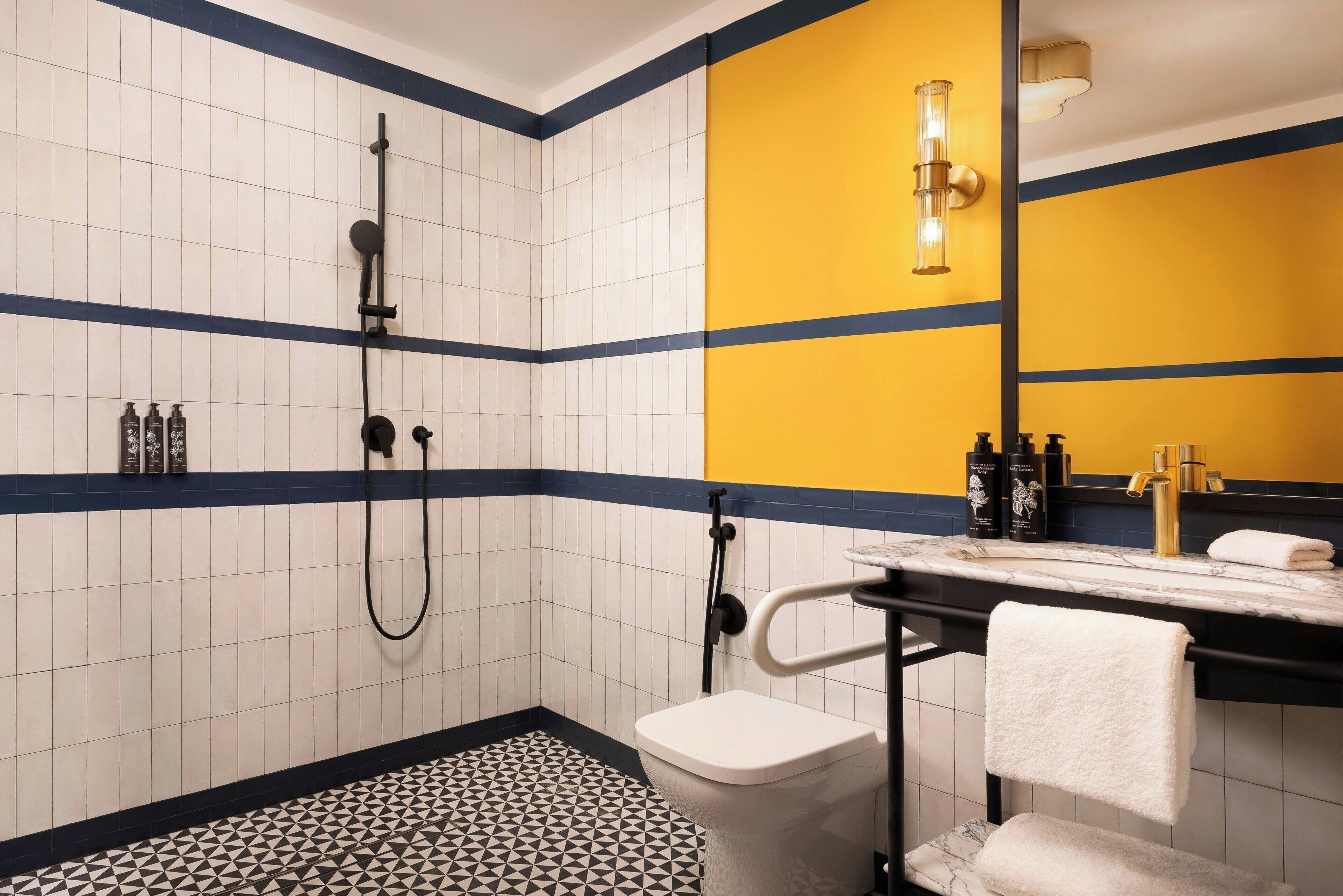 A bathroom with a shower, toilet, and sink with a towel hanging.