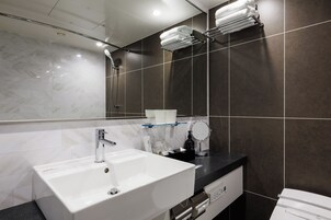 A modern bathroom with a white sink, a mirror, and a towel rack.