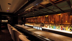 A bar area with a long counter, multiple seating options, and a variety of bottles and glasses. - Hotel Metropolitan Edmont Tokyo (Tokyo)
