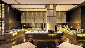 A modern restaurant with a central island, multiple seating areas, and a patterned wall design. - Hotel Metropolitan Edmont Tokyo (Tokyo)