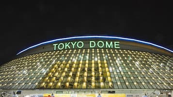 The exterior of Tokyo Dome at night with illuminated signage.