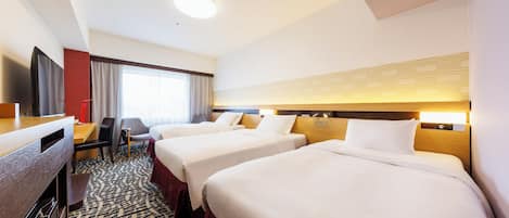 A hotel room with two beds, a desk, a TV, and a large window.