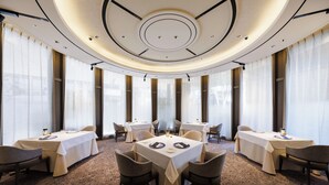 A modern dining area with round tables, chairs, and a carpeted floor. - Hotel Metropolitan Edmont Tokyo (Tokyo)