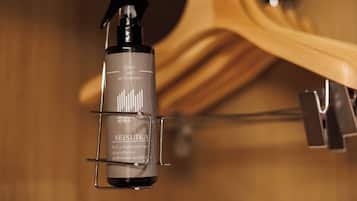 A bottle of Seisuka fabric and air freshener hanging on a metal clip.