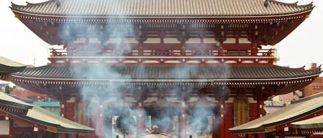 Un edificio japonés tradicional con tejado escalonado y una multitud de personas frente a él.
