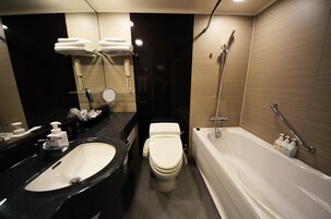 A modern bathroom with a black sink, white toilet, and a white bathtub.