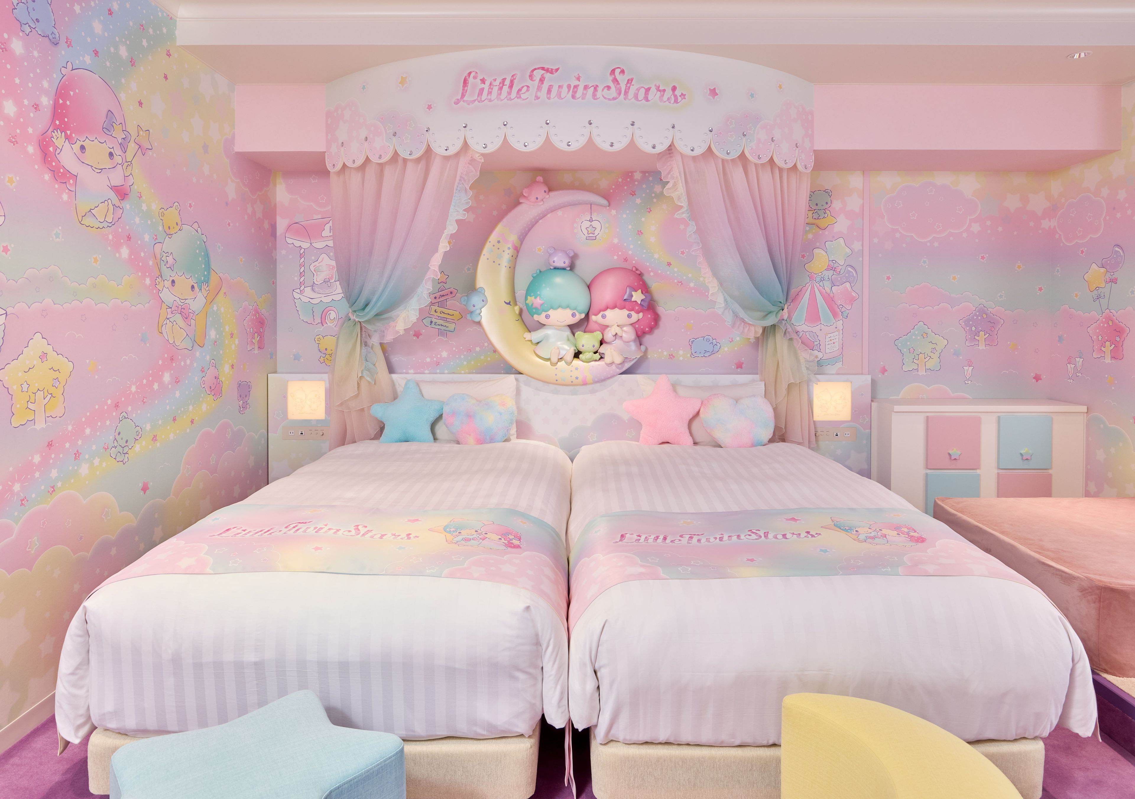 A twin bedroom with two beds, a decorative headboard, and a nightstand.