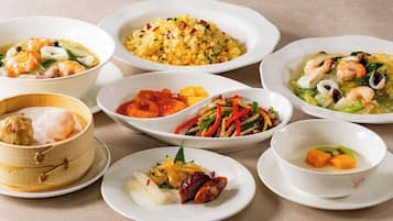 A variety of dishes including seafood, rice, and vegetables, suggesting a diverse meal selection.