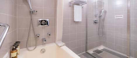 Un baño moderno con bañera, ducha con puerta de vidrio y un perchero para toallas.