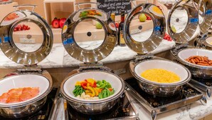 Un bufé con diversos alimentos, incluyendo carnes, verduras y frutas.