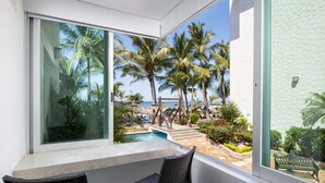 A balcony with a view of a pool, palm trees, and a beach. - Villa Varadero (Nuevo Nayarit)