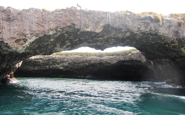 Un arco de roca natural sobre un cuerpo de agua.
