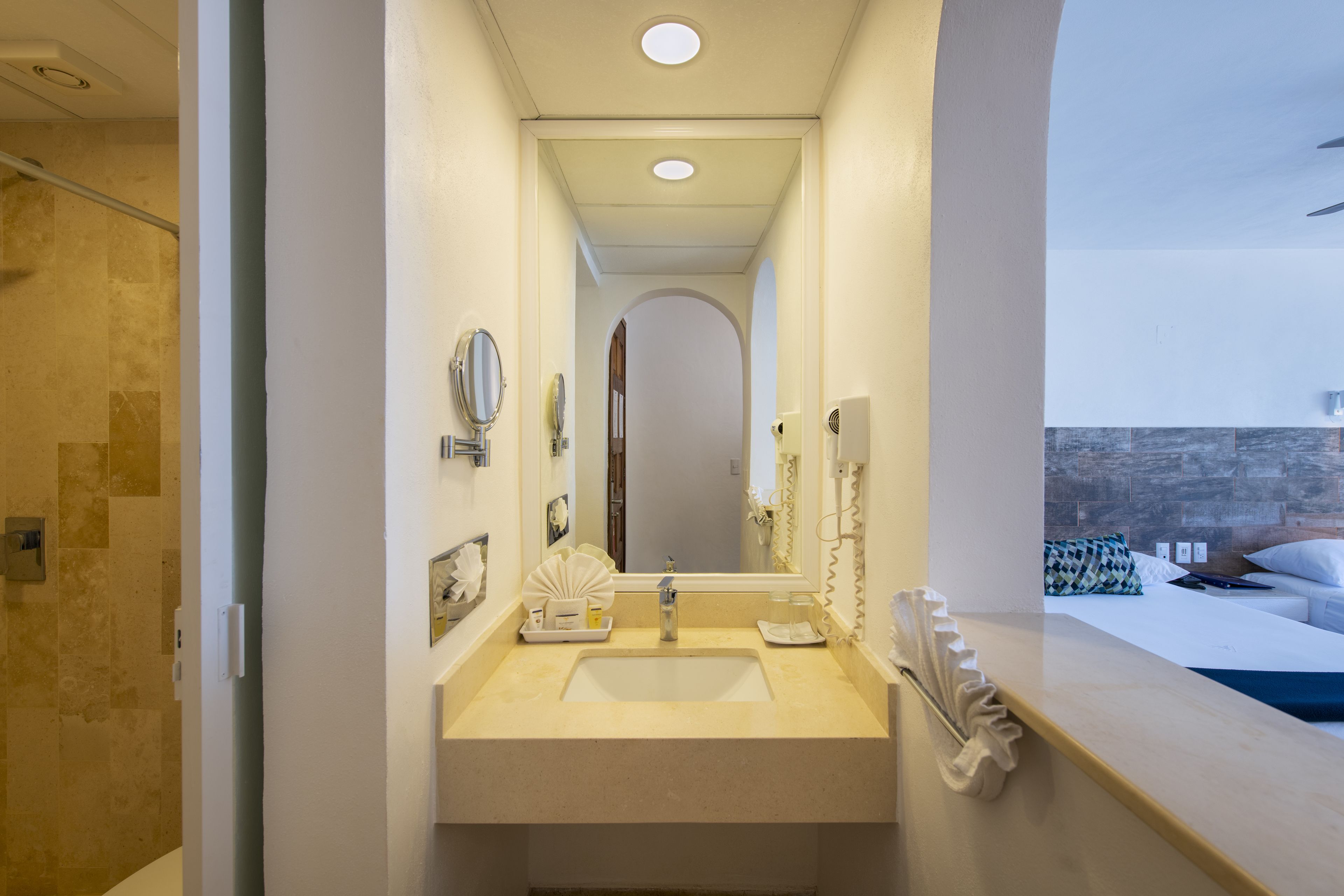 Une salle de bain d’hôtel équipée d’un lavabo, d’un miroir et d’articles de toilette.