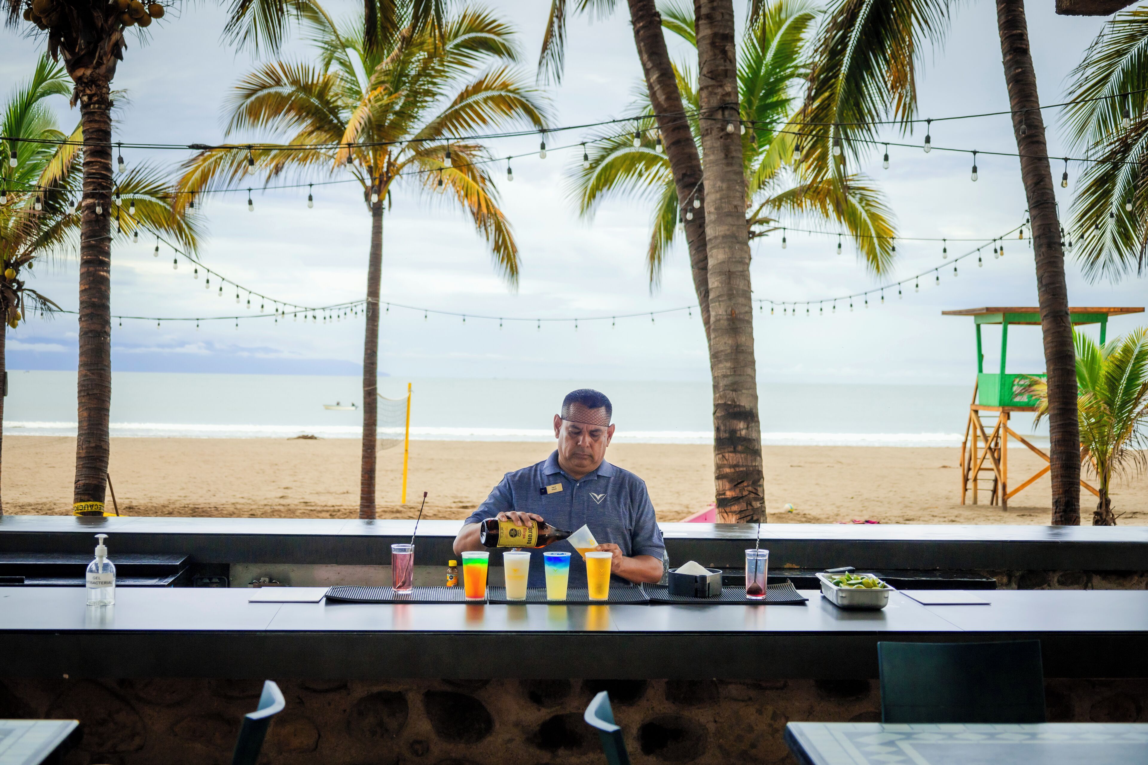 Eine Bar mit Blick auf den Strand und Palmen.