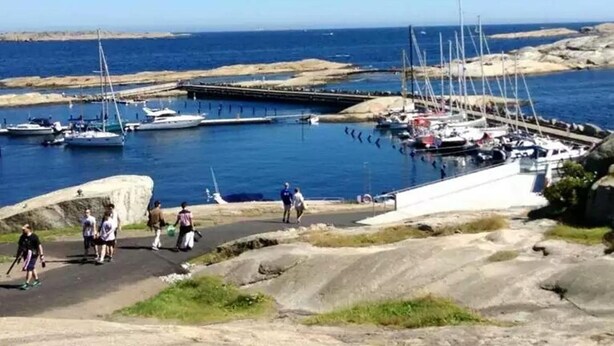 A coastal marina with boats docked, rocky terrain, and clear skies. - Maritim Hotel (Tønsberg)