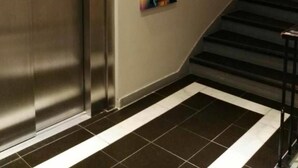An elevator, a staircase, and a colorful abstract painting on the wall. - Maritim Hotel (Tønsberg)
