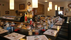 A buffet setup with various food items and condiments, a clock on the wall, and a traditional Japanese doll. - Maritim Hotel (Tønsberg)