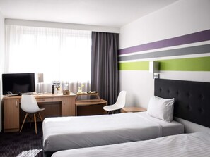 A hotel room with a bed, a desk with a computer, a chair, and a TV. - ibis Styles Bielsko-Biala (Bielsko-Biala)
