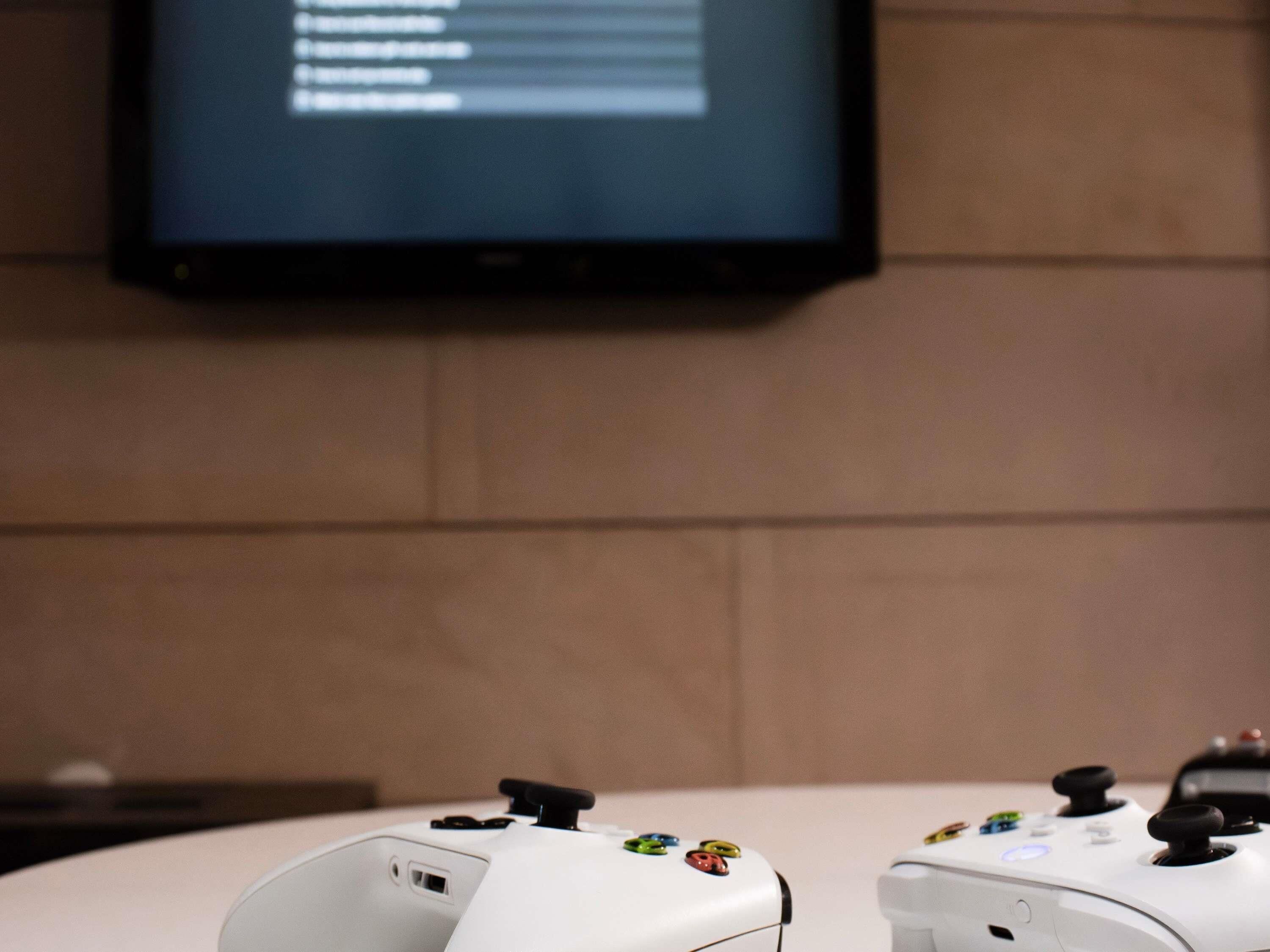 Una consola de videojuegos blanca con botones de colores y un puerto USB, sobre una mesa.