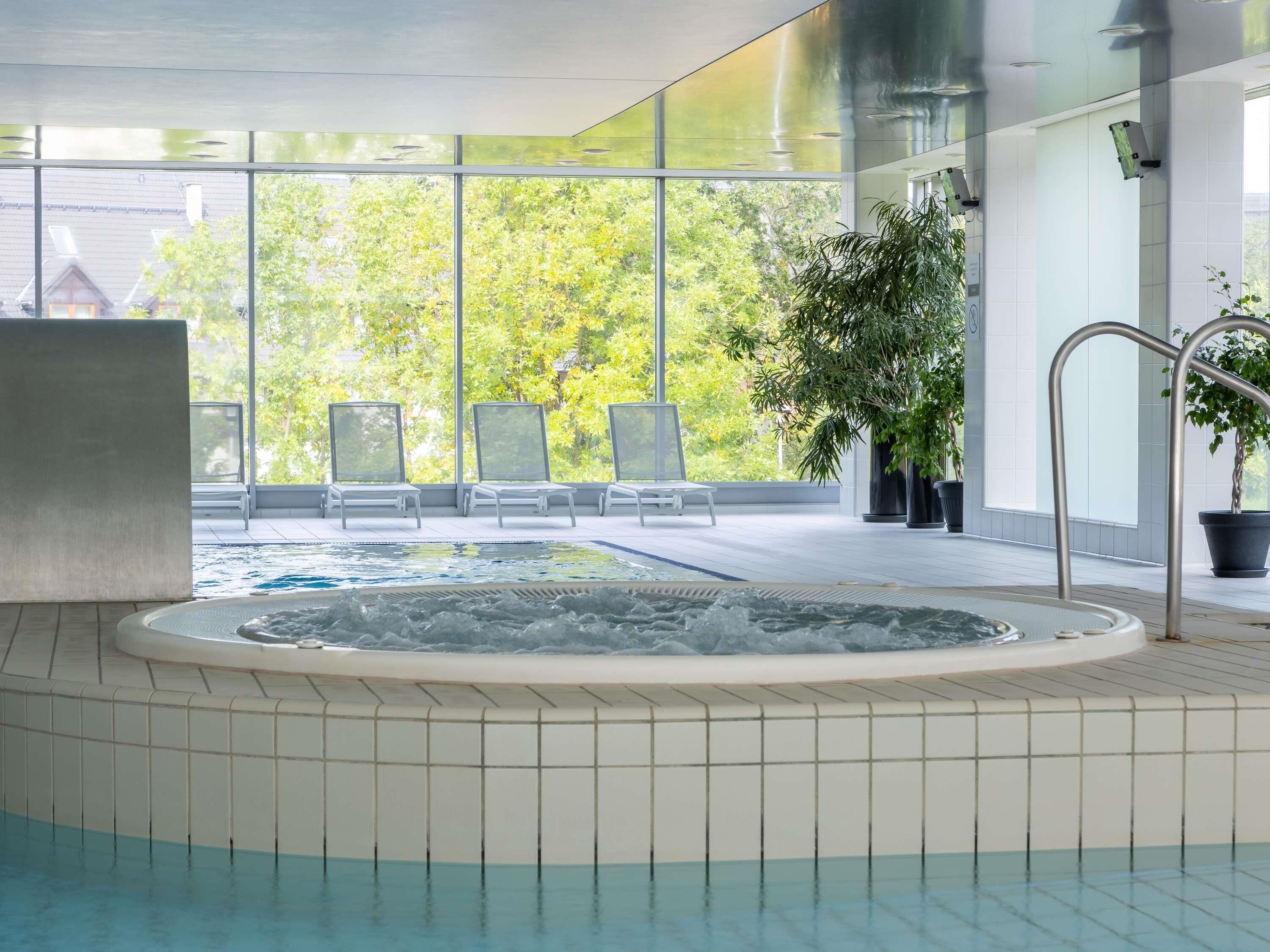 Una piscina techada, sillones reclinables de piscina