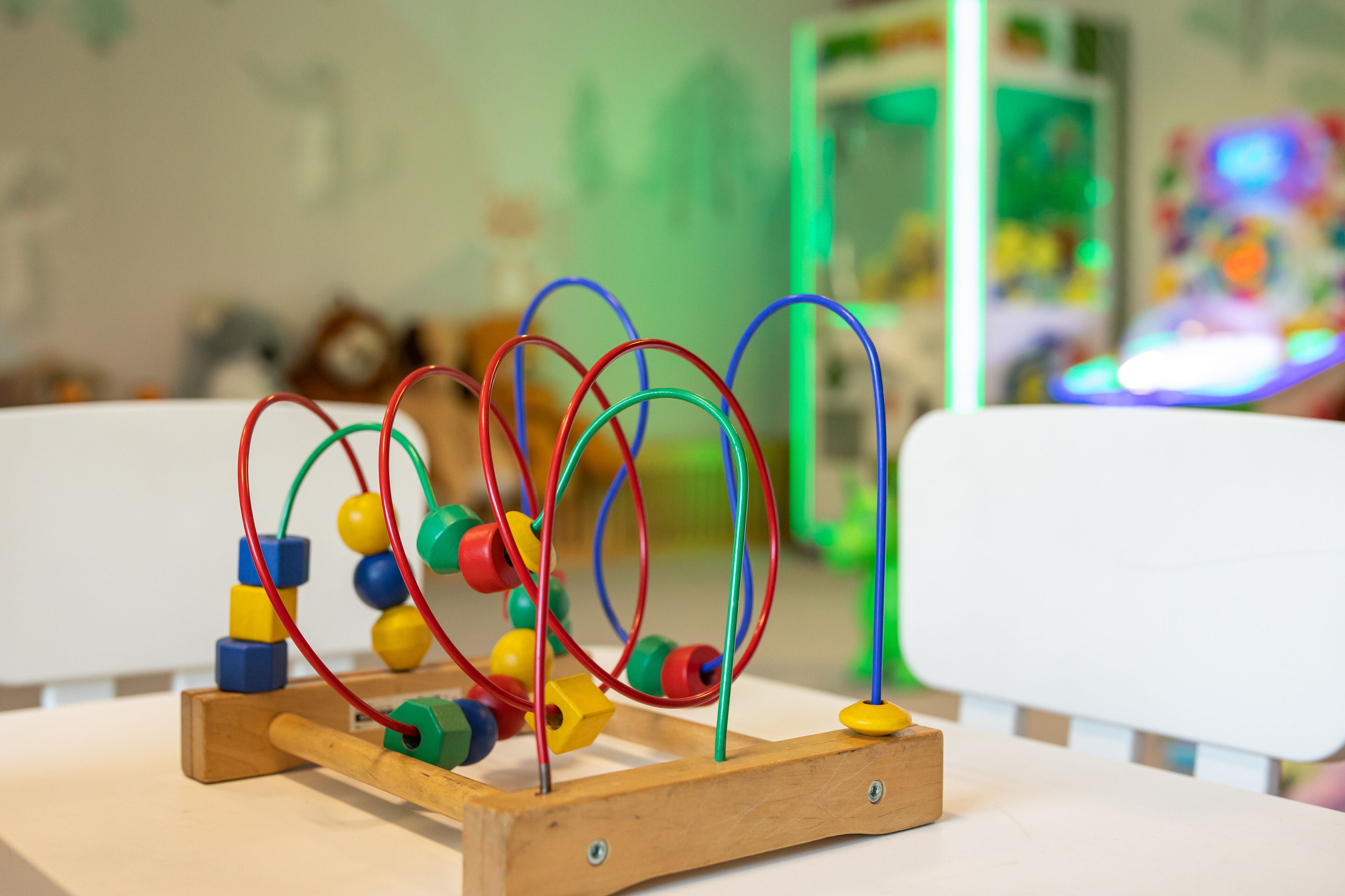 A wooden abacus with colorful beads and wires on a table.