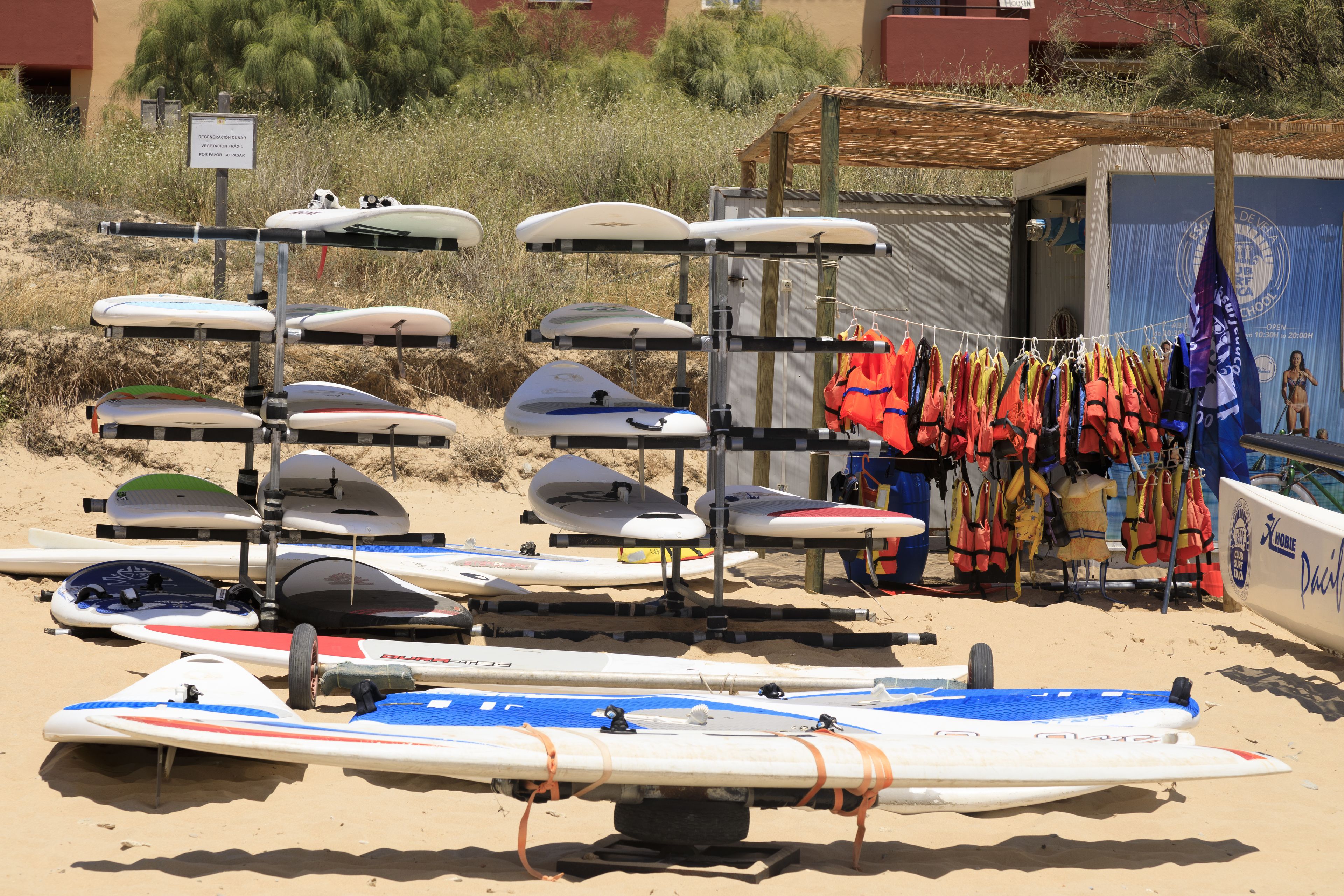 A beach with surfboards and life vests.