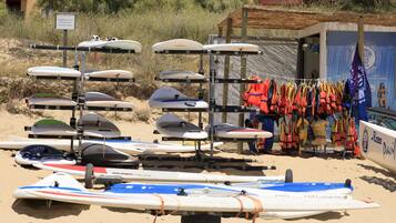 A beach with surfboards and life vests.
