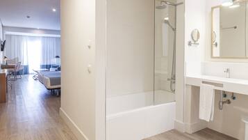 A modern bathroom with a glass-enclosed shower, a bathtub, and a vanity with a mirror.