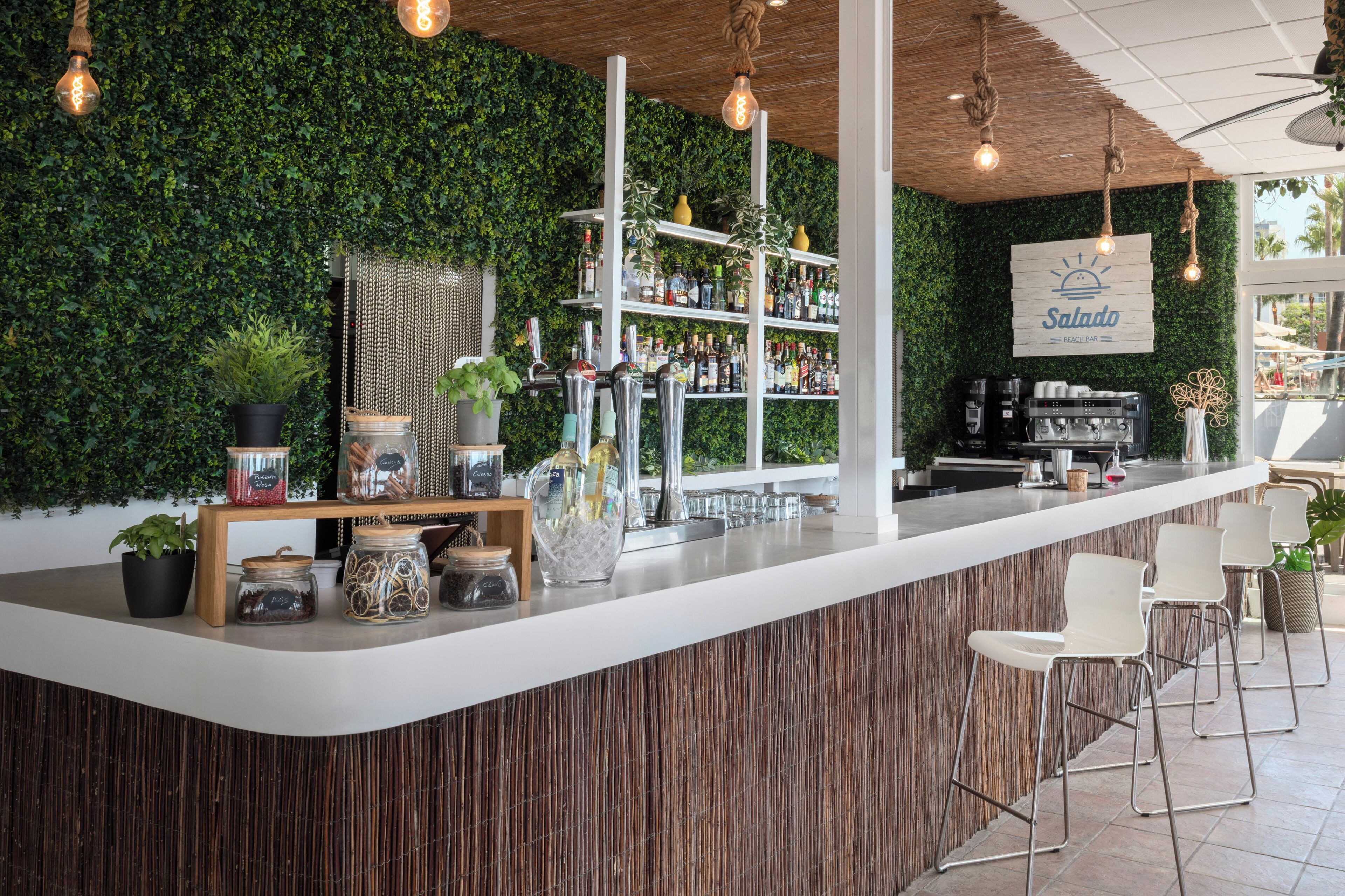 Zona de bar con mostrador de madera, estantes con botellas y un cartel que dice "Salada".