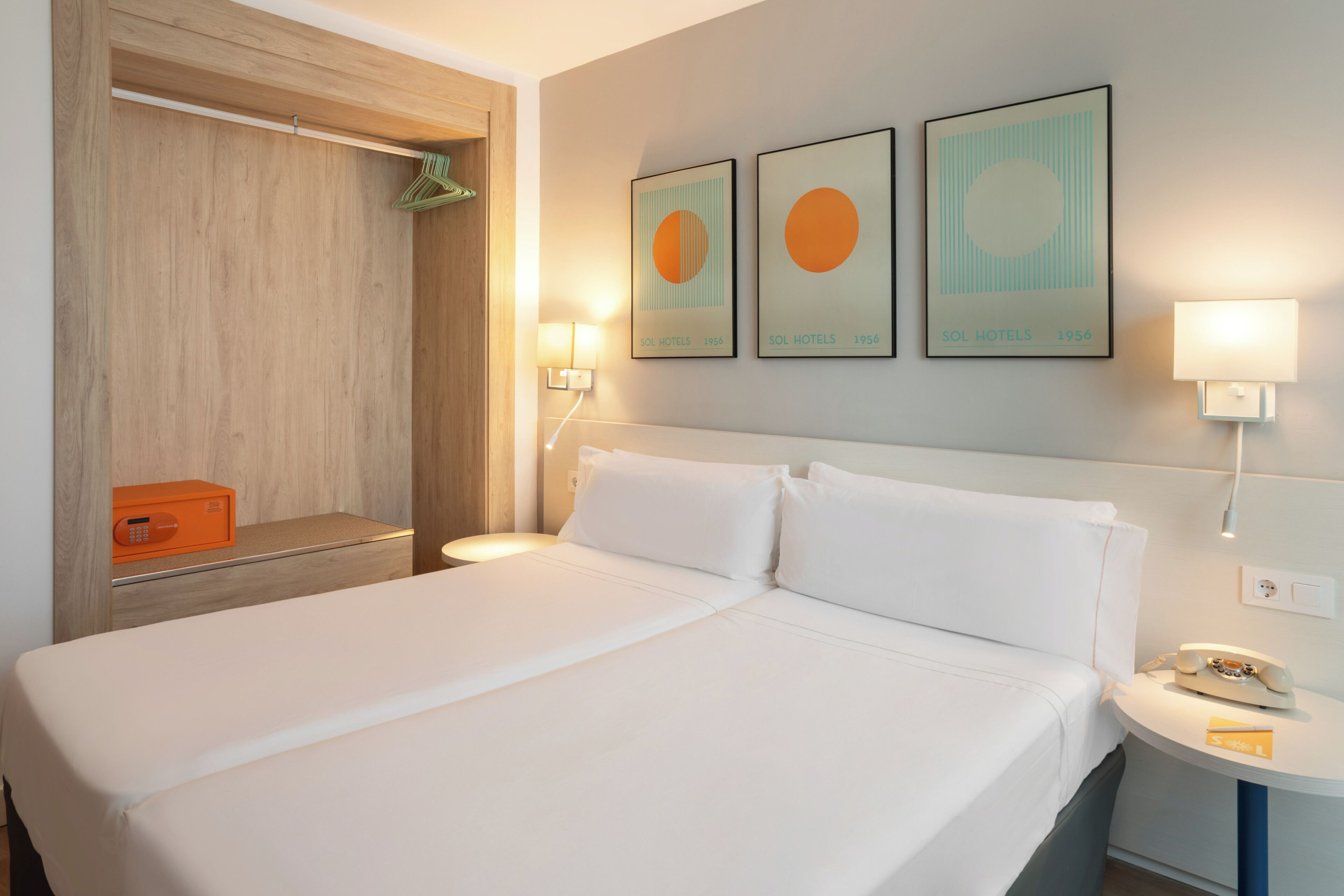 Une chambre d’hôtel avec un lit, une table de chevet, une lampe et un tableau au mur.