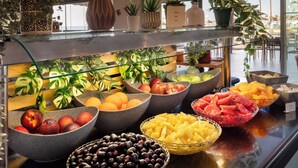 Une présentation de fruits comprenant différents types de fruits disposés dans des bols et des paniers.