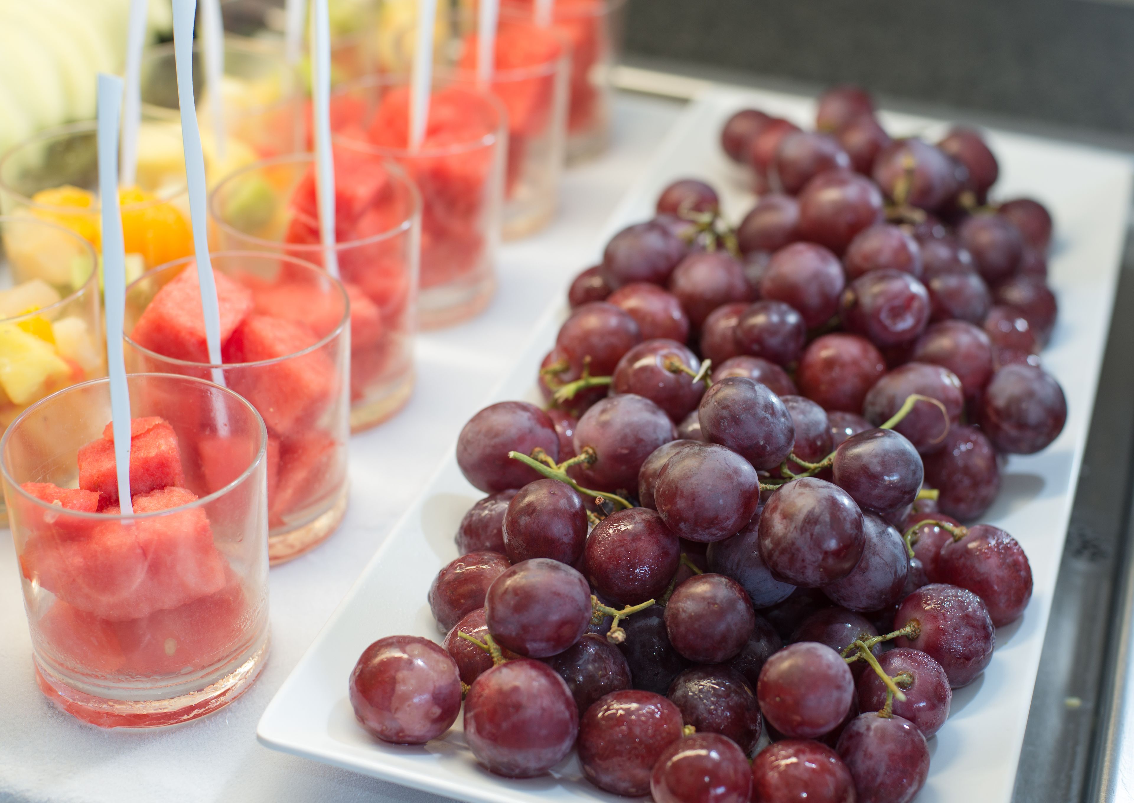 Une table garnie d’une variété de fruits et une assiette de raisins.