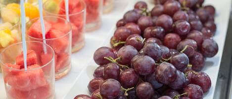 Une table garnie d’une variété de fruits et une assiette de raisins.