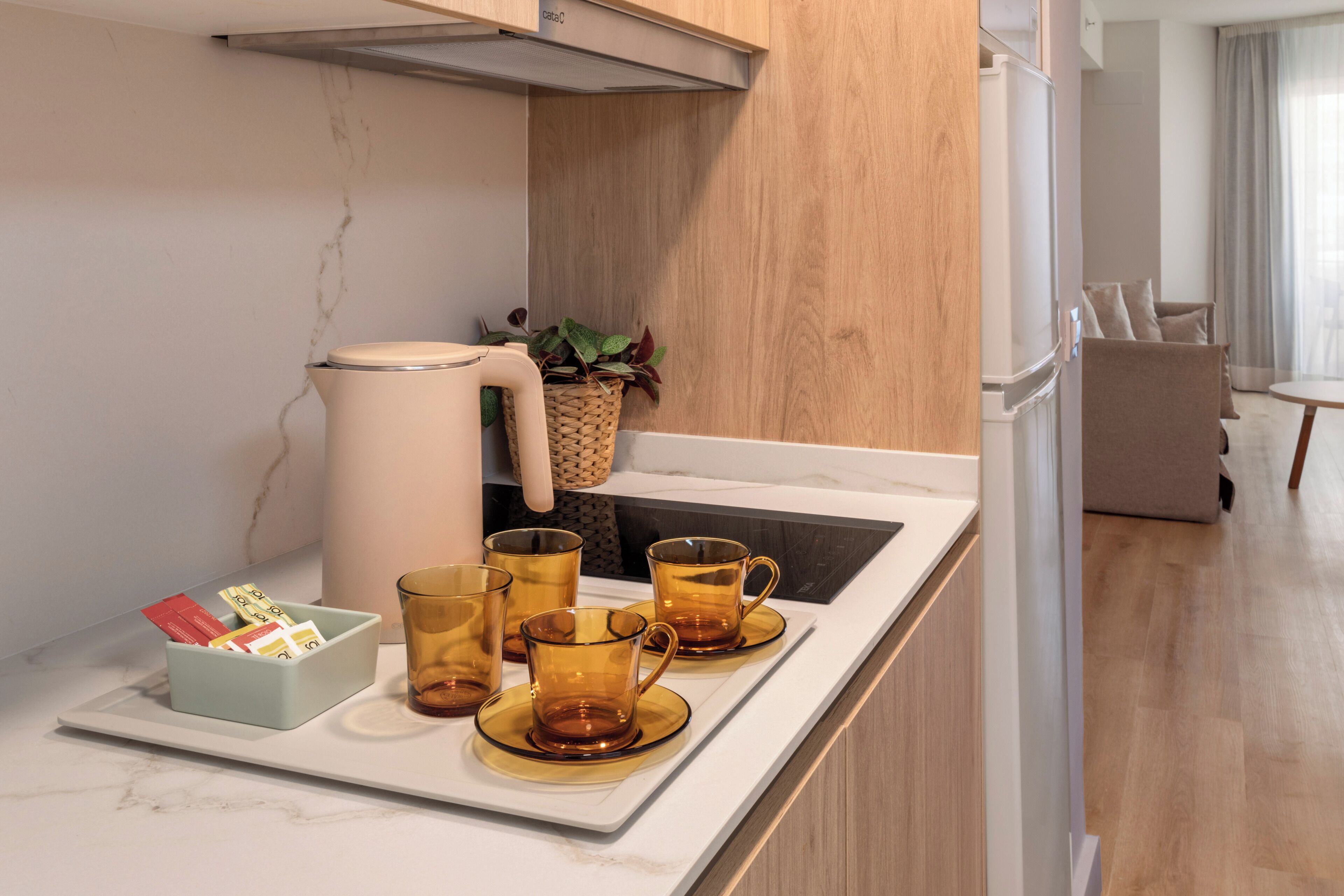 A modern kitchen with a marble countertop, a built-in oven, and a sink.
