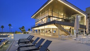 Un hotel moderno con piscina, zona de estar al aire libre y un bar.