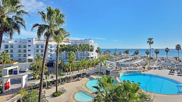 Een binnenzwembad, 8 buitenzwembaden en parasols bij het zwembad