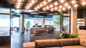 A modern office space with a central bar area, seating, and large windows. - Quality Hotel Grand Boras (Borås)
