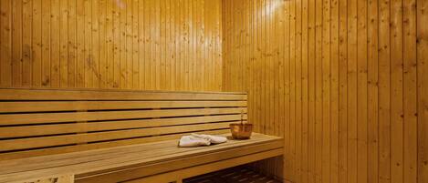 A wooden sauna with a bench and a bowl.