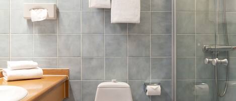 Un baño con inodoro, lavabo y ducha.