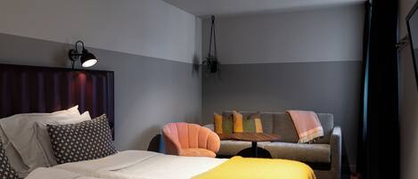 Un dormitorio moderno con una cama, un sofá y una planta colgante.