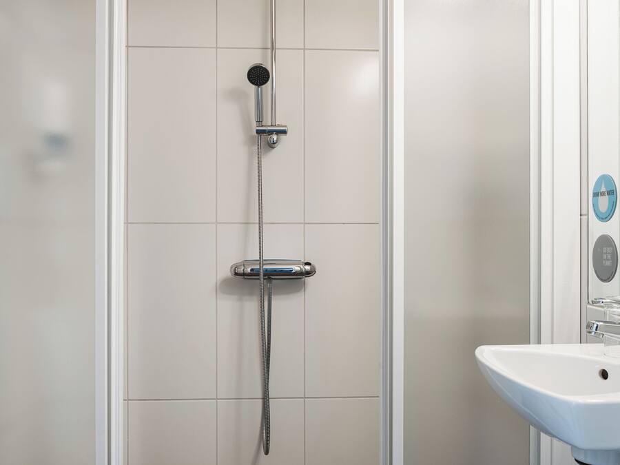 A modern bathroom with a shower enclosure, a sink, and a mirror.